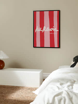 Gerahmtes Poster mit roten und rosa Streifen und weißer Schrift an beiger Schlafzimmerwand