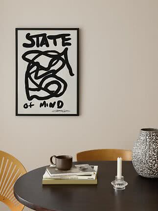 Indrammet sort-hvid plakat med teksten "State of Mind" over et rundt spisebord