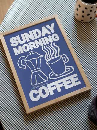Niebieski plakat w ramie z napisem Sunday Morning Coffee oraz rysunkiem filiżanki i kawiarki