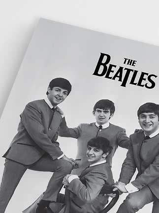 Black-and-white poster of The Beatles with four members in matching suits.
