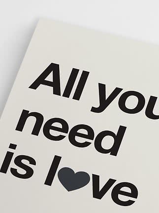 Närbild av typografisk poster med svart text på vit bakgrund och ett mörkt hjärta