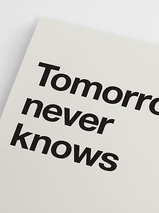 Gros plan d’une affiche blanche avec typographie noire "Tomorrow never knows"