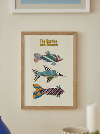 Oprawiony plakat The Beatles Yellow Submarine z trzema kolorowymi rybami na jasnej ścianie