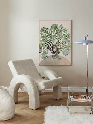 Living room with cream lounge chair, floor lamp and framed botanical wall art
