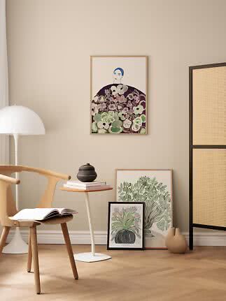 Stilrent hjørne med træstol, sidebord og indrammede botaniske plakater på beige væg