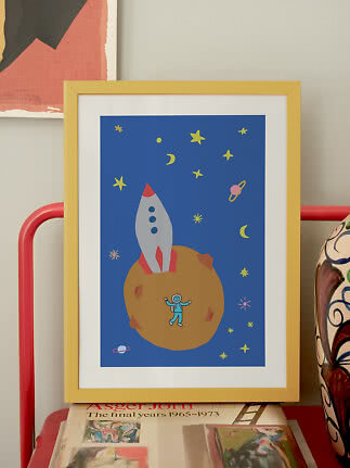 Gul indrammet børneplakat med raket og astronaut på en planet i rummet