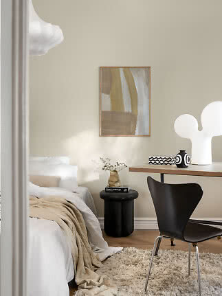 Modernes Schlafzimmer mit Bett, Schreibtisch, schwarzem Stuhl, abstraktem Bild und weißer Tischlampe