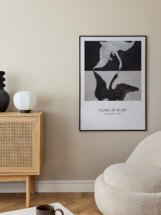 Inramad Hilma af Klint-poster med två svanar på beige vägg i ett modernt vardagsrum