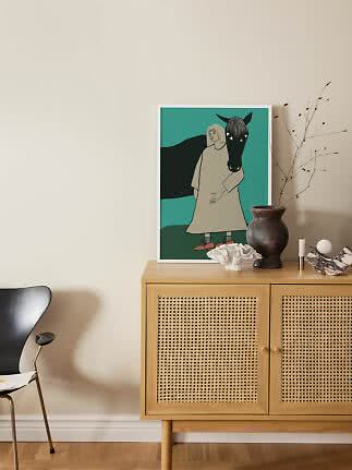 Indrammet illustration af kvinde med sort hest på turkis baggrund, placeret på egetræsskænk