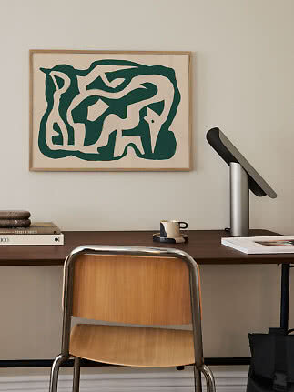 Desk with wooden chair, table lamp and abstract green and white wall art