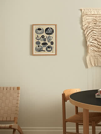 Framed kitchen illustration with cups and pastries on a light wall above a dining table