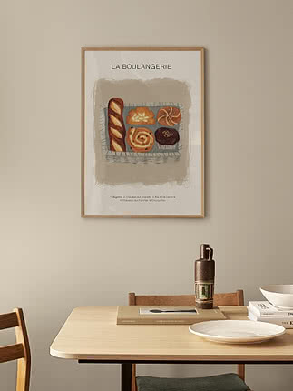 Poster incorniciato con illustrazione di panetteria e scritta 'La Boulangerie' su parete beige