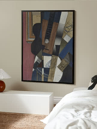 Framed abstract painting with a guitar motif in blue, brown and beige tones on the wall