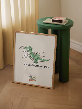 Gerahmtes Toy Story-Poster mit grünem Dinosaurier, an einen grünen runden Beistelltisch gelehnt
