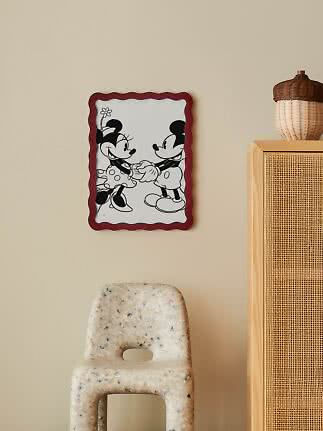 Zwart-witte Mickey en Minnie poster met golvende rode rand aan beige muur
