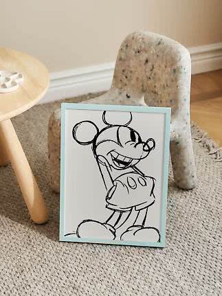 Ingelijste zwart-witte Mickey Mouse-poster met lichtblauw frame op de vloer voor een kinderstoel