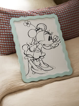 Decoratief kussen met Minnie Mouse-illustratie en lichtblauwe golfrand op bed