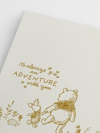 Weiße Karte mit goldener Winnie Puuh- und Ferkel-Illustration und dem Text "It's always an adventure with you"