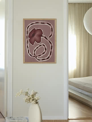 Indrammet abstrakt blomsterplakat i rosa og bordeaux på lys væg