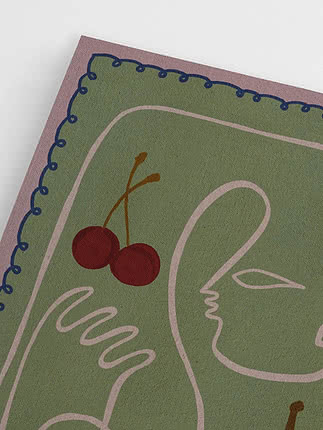Primer plano de lámina verde con rostro abstracto y cerezas rojas, borde rosa