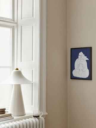White table lamp on windowsill by radiator with a small blue framed artwork on the wall