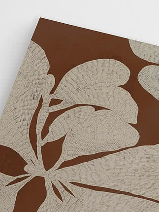 Close-up of botanical wall art with cream leaves on a brown background