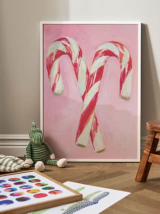 Indrammet plakat med malede sukkerstokke i pink, rød og hvid mod lyserød baggrund