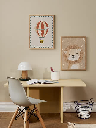 Bureau d'enfant avec chaise blanche, lampe et deux affiches encadrées ballon et lion
