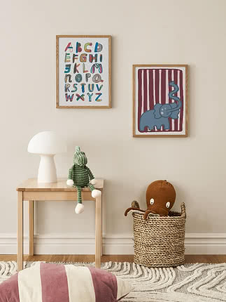 Kinderzimmer mit Alphabetposter, Elefantenbild, weißer Lampe, grünem Kuscheltier und Korb mit Oktopus