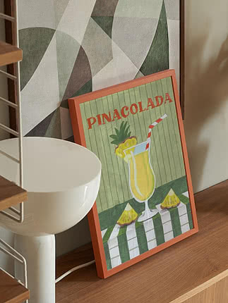 Framed Piña Colada poster with tropical cocktail, pineapple and straw on a wooden shelf