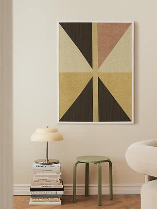 Geometrisk plakat i hvid ramme over en grøn skammel og en stak bøger