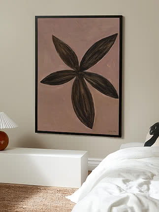 Affiche florale encadrée de noir au-dessus d'un banc blanc dans une chambre