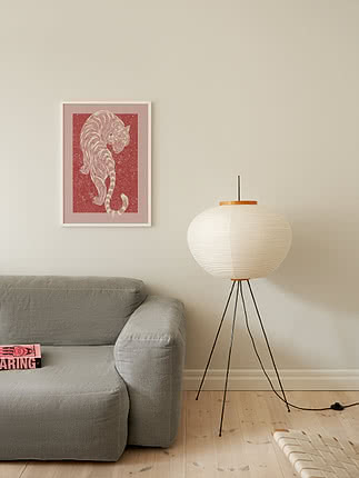 Trykket Mystic Red Tiger i hvid ramme på en beige væg over en salviegrøn hørsofa ved siden af en gulvlampe i papir