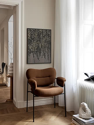 Trycket Cascading Foliage i mörk ram på beige vägg ovanför en fåtölj i konjaksfärgad sammet vid ett fönster