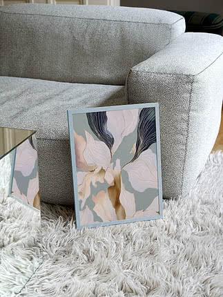 Trykket Floral Abstraction i blegblå ramme lænet op ad en grå bouclésofa på et hvidt flossetæppe