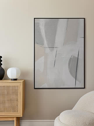 Trykket Subtle Calm i sort ramme på en beige væg over et skænk i lys eg med rattanlåger og en hvid kuglelampe