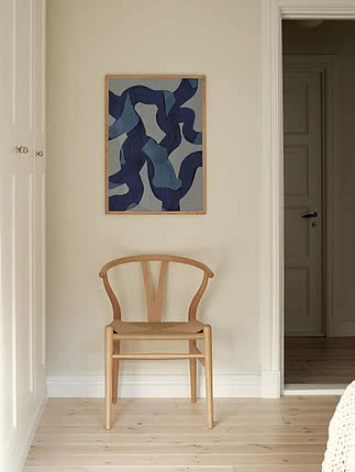 Druck Ultramarine Swirls im Eichenrahmen an cremefarbener Flurwand über einem Wishbone Stuhl aus heller Eiche
