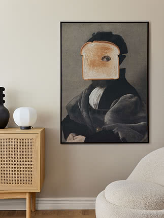 Plakaten Surreal Toast Portrait i svart ramme på en beige vegg over et skjenk i eik med rattandører, en svart riflet vase og en hvit kulelampe, ved siden av en kremfarget bouclé-stol