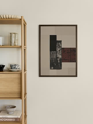 Plakat Abstract Harmony w ramie z ciemnego drewna na kremowej ścianie obok dębowego regału z ceramiką, cętkowanym wazonem i ułożonymi w stos książkami