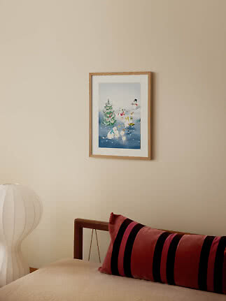 Affiche d’hiver encadrée en bois avec personnages et sapin au-dessus d’un lit.