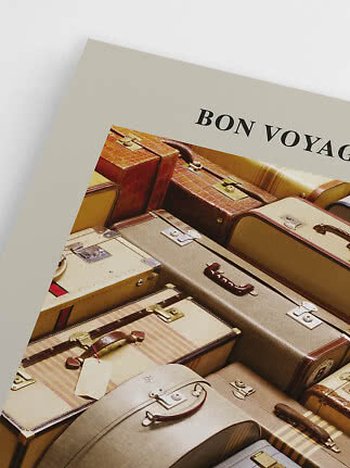 Plakat med teksten "Bon Voyage" over en stak vintage kufferter i beige og brun.