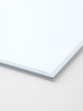 Close-up of a white picture frame with a minimalist aluminum profile.