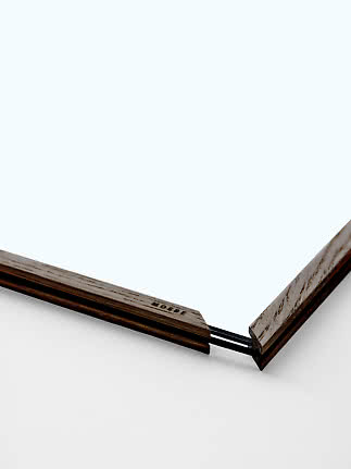 Close-up of minimalist wooden frame with glass and black rubber bands at the corner