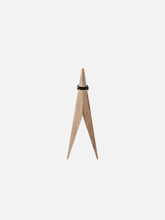 Moebe Pinch oak stand, front view with two pointed wooden legs and a black rubber ring