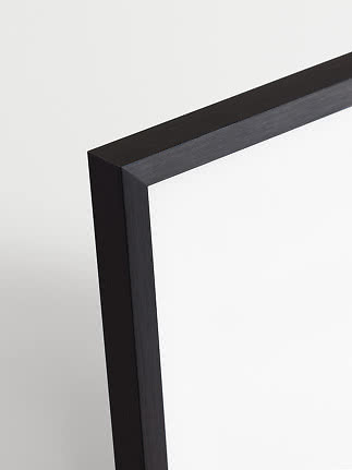 Close-up of a black metal frame with a clean corner joint against a light background