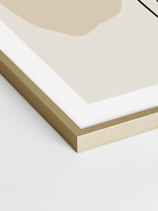 Close-up of framed abstract art print with light wood frame and beige shapes