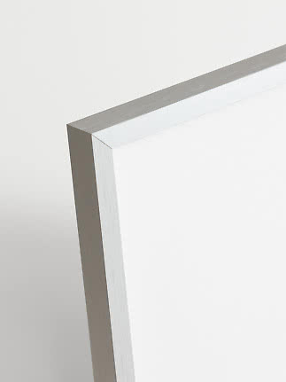 Close-up of the corner of a silver aluminum frame against a white background