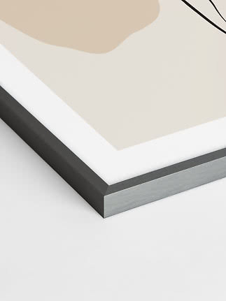 Close-up of framed abstract print with black metal frame and beige shapes
