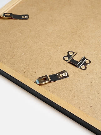 Retro di una cornice quadrata in nero con il pannello posteriore in MDF e gli attacchi metallici per appenderla