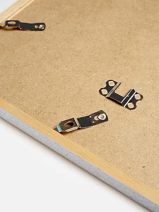 Retro di una cornice quadrata in bianco con il pannello posteriore in MDF e gli attacchi metallici per appenderla